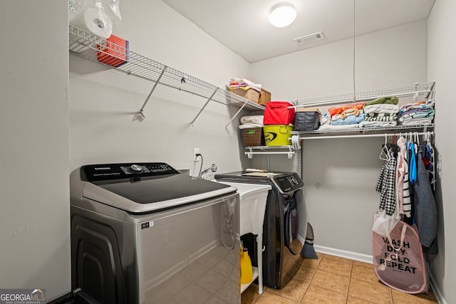 washroom with light tile patterned flooring and separate washer and dryer