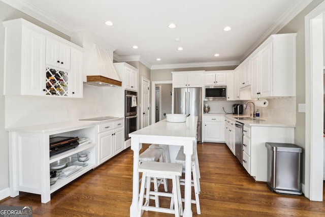 kitchen featuring stainless steel appliances, premium range hood, sink, and white cabinets