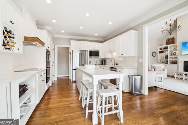 kitchen with white cabinetry, a center island, appliances with stainless steel finishes, dark hardwood / wood-style flooring, and a kitchen breakfast bar