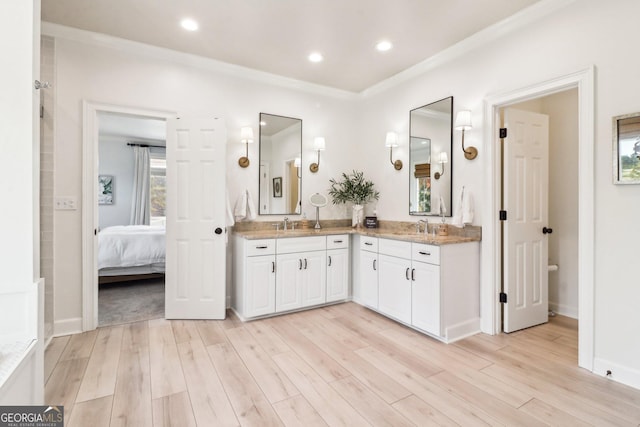 bathroom featuring vanity, hardwood / wood-style floors, and crown molding