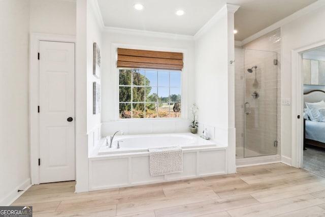 bathroom featuring crown molding, hardwood / wood-style flooring, and shower with separate bathtub