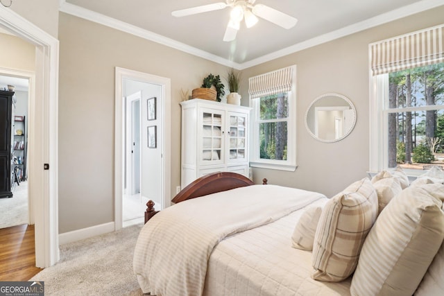 carpeted bedroom with ornamental molding and ceiling fan