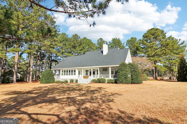 cape cod home featuring a sunroom and a front lawn