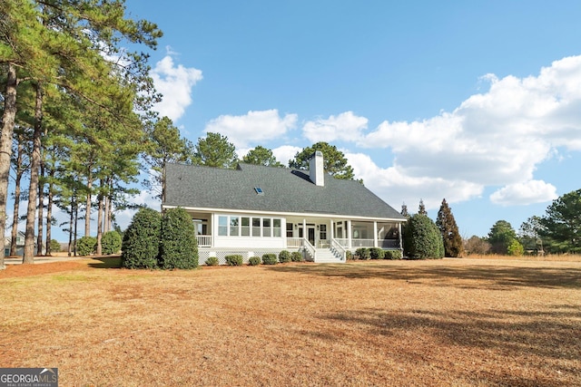 back of property featuring a sunroom and a lawn