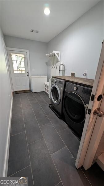 washroom featuring dark tile patterned floors and washing machine and clothes dryer