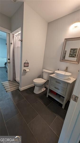 bathroom featuring vanity, tile patterned floors, and toilet