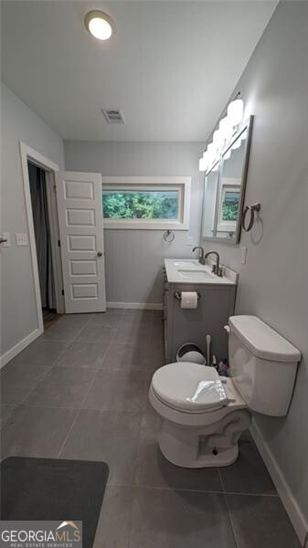 bathroom featuring vanity, tile patterned floors, and toilet