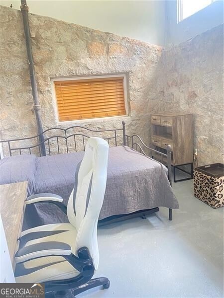 bedroom featuring concrete flooring