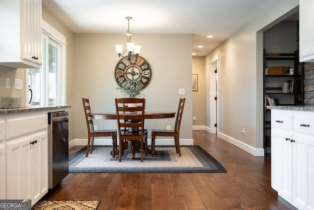 dining space with dark hardwood / wood-style floors and a chandelier