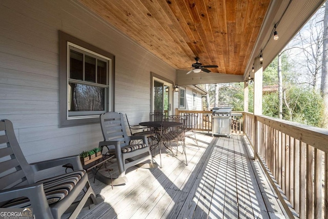 wooden deck with area for grilling and ceiling fan