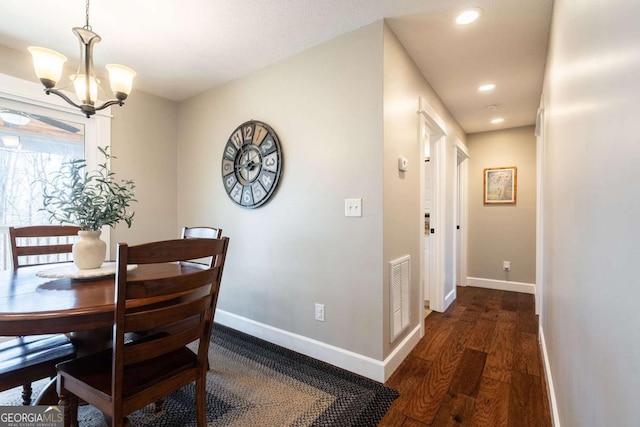 dining area featuring dark wood-type flooring and a chandelier