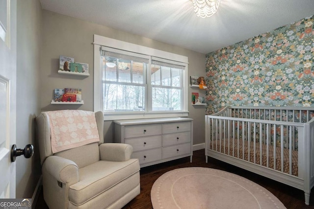 bedroom featuring dark wood-type flooring and a nursery area