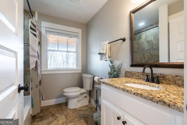 bathroom featuring vanity, toilet, and walk in shower