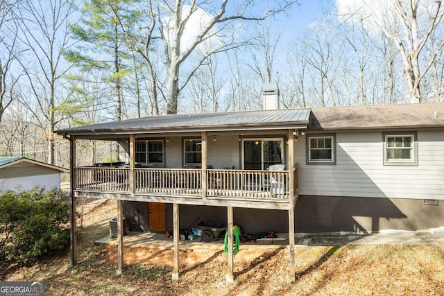 back of house featuring cooling unit and a wooden deck