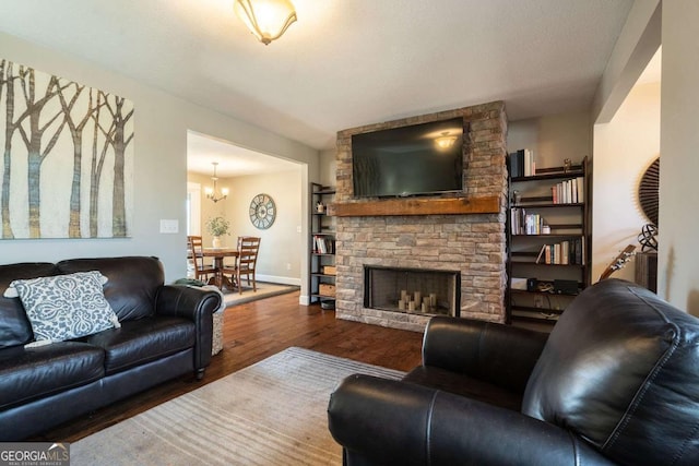 living room featuring hardwood / wood-style floors, a notable chandelier, and a fireplace