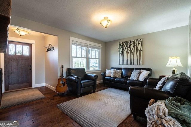 living room featuring dark hardwood / wood-style flooring and a textured ceiling