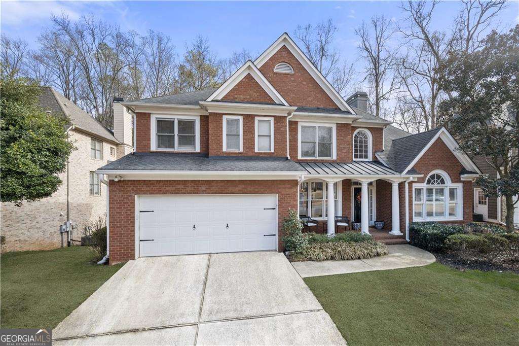 view of front of property with covered porch, a front yard, and a garage