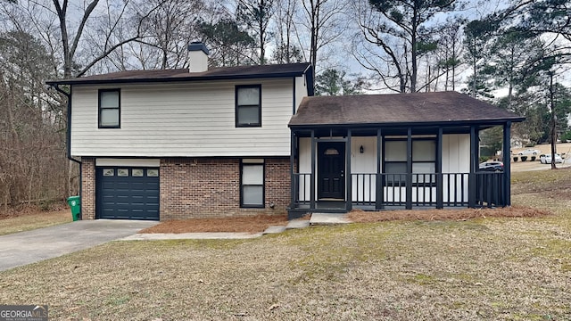 split level home featuring a garage, covered porch, and a front lawn