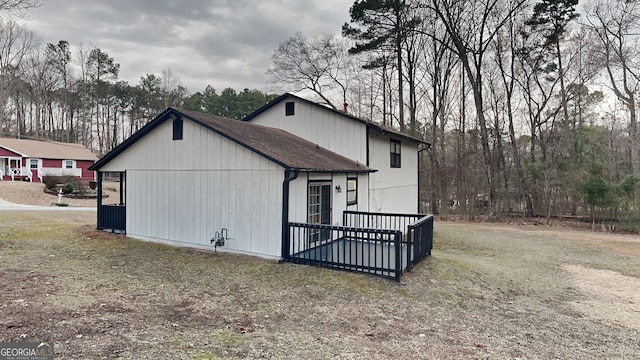 view of side of property featuring a wooden deck and a yard