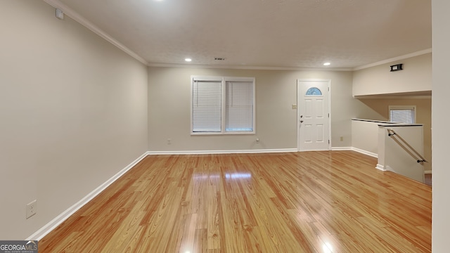 foyer entrance with crown molding and light hardwood / wood-style floors