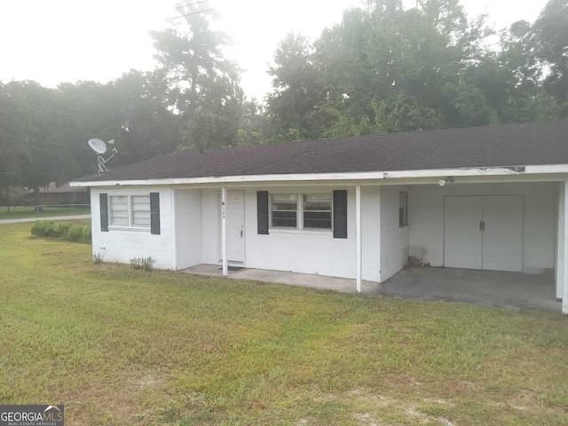 ranch-style home featuring a carport and a front yard