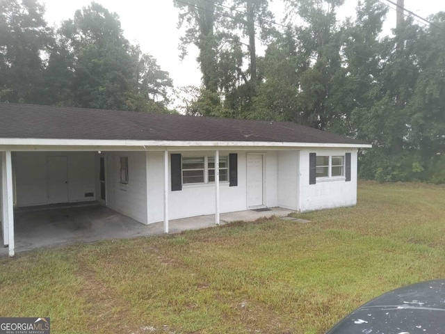 ranch-style home with a carport and a front lawn