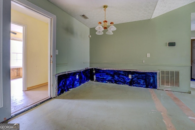 unfurnished dining area with an inviting chandelier, concrete flooring, and a textured ceiling