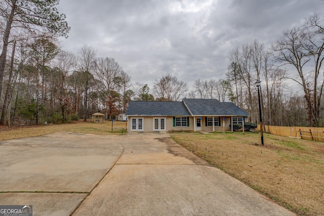 ranch-style house with an outbuilding, a front yard, and french doors