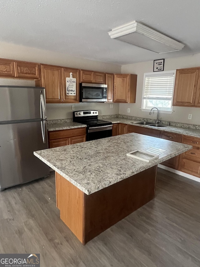 kitchen featuring a kitchen island, appliances with stainless steel finishes, sink, and dark wood-type flooring