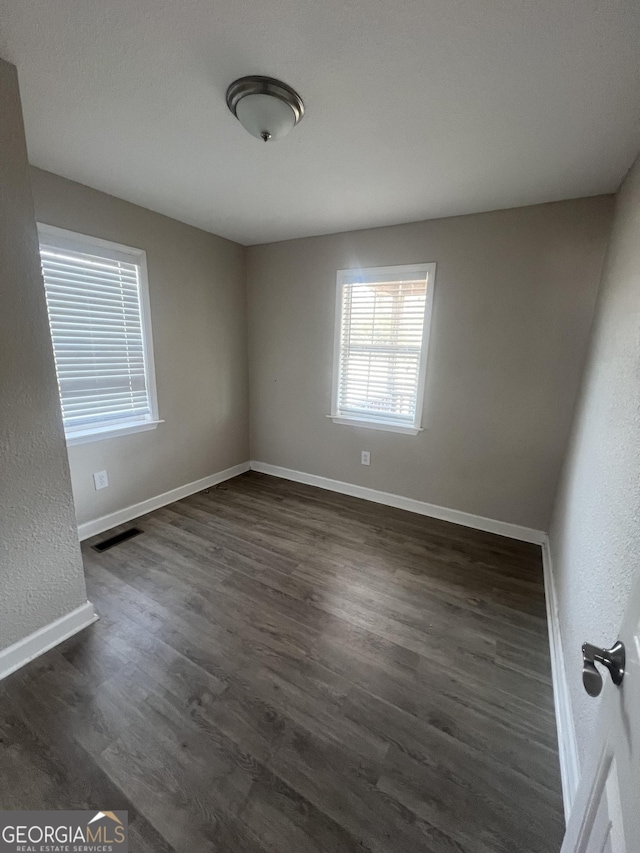 spare room featuring dark wood-type flooring