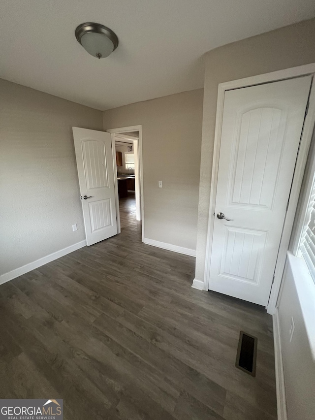 unfurnished bedroom featuring dark wood-type flooring