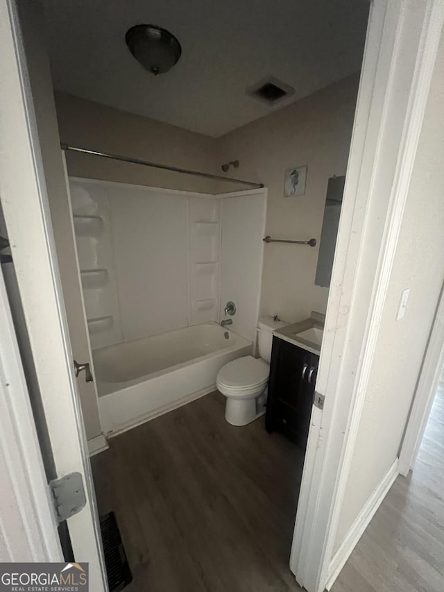 full bathroom featuring wood-type flooring, toilet, shower / washtub combination, and vanity