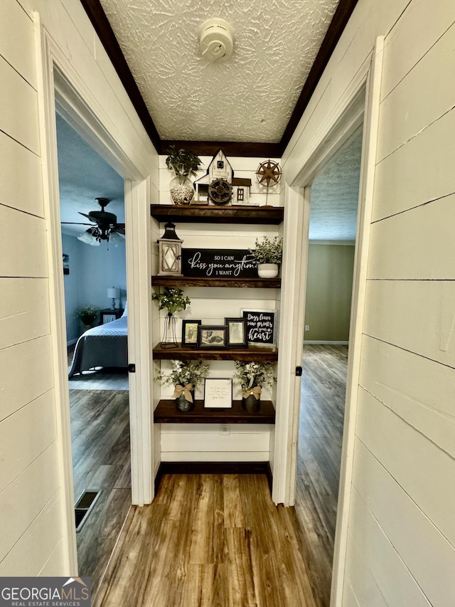 corridor featuring a textured ceiling and hardwood / wood-style flooring