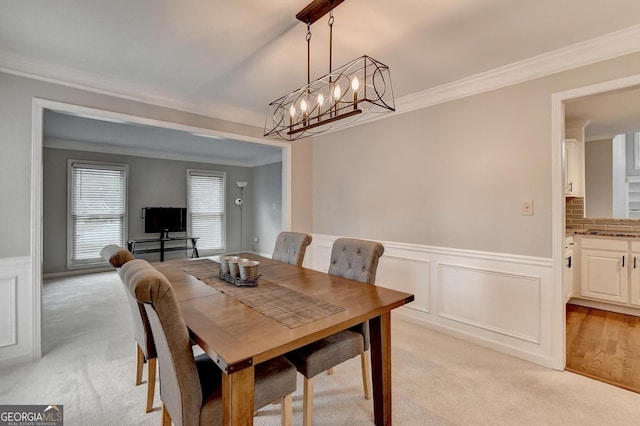 carpeted dining space featuring crown molding