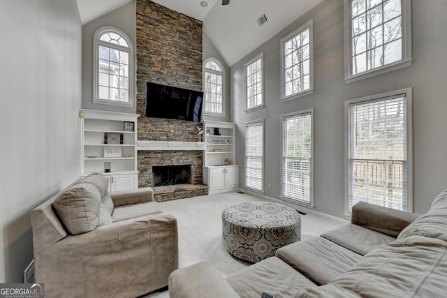 living room with a fireplace, high vaulted ceiling, a healthy amount of sunlight, and carpet