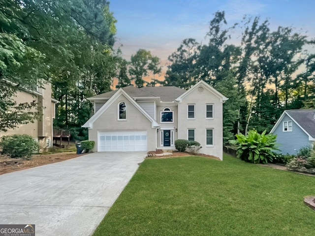 view of front of house with a garage and a yard