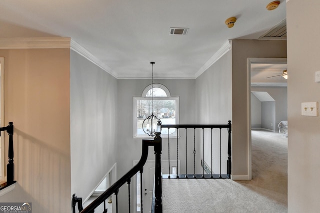 corridor with crown molding, carpet floors, and a chandelier