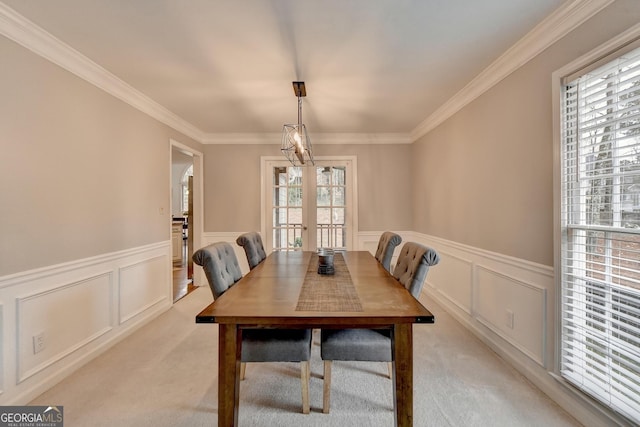 dining room with crown molding, light colored carpet, and french doors