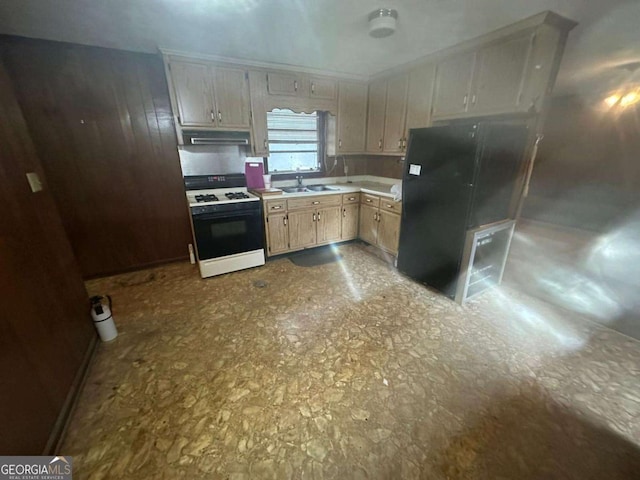 kitchen with light brown cabinetry, sink, and range with gas cooktop