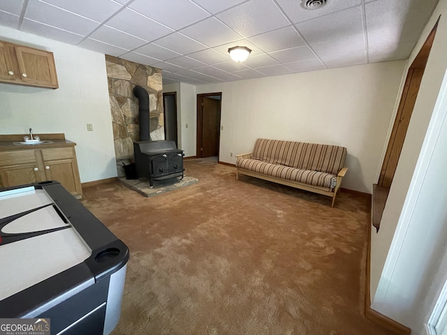 31 Hilltop Dr, Hayesville, NC 28904 - interior space featuring sink, a paneled ceiling, a wood stove, and dark colored carpet