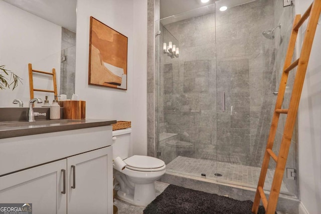 bathroom featuring vanity, toilet, and a stall shower