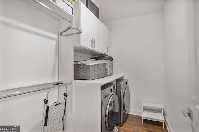 laundry room with washing machine and clothes dryer, cabinet space, dark wood finished floors, and baseboards