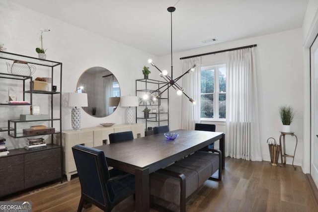 dining room featuring dark wood-type flooring and a chandelier