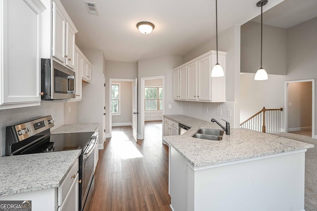 kitchen with hanging light fixtures, appliances with stainless steel finishes, sink, and white cabinets