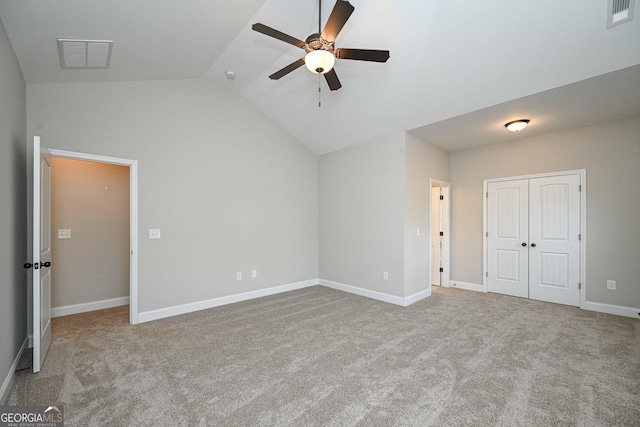 unfurnished bedroom with ceiling fan, light carpet, a closet, and lofted ceiling