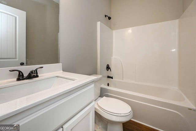 full bathroom featuring hardwood / wood-style flooring, shower / bathing tub combination, vanity, and toilet