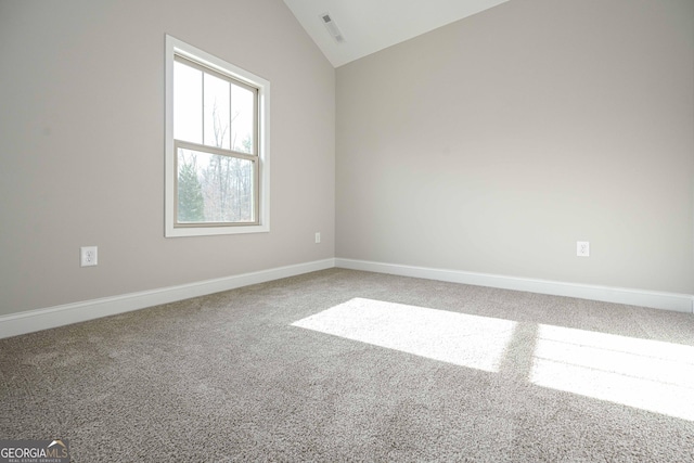 carpeted empty room featuring lofted ceiling