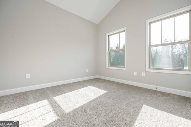 carpeted spare room with vaulted ceiling