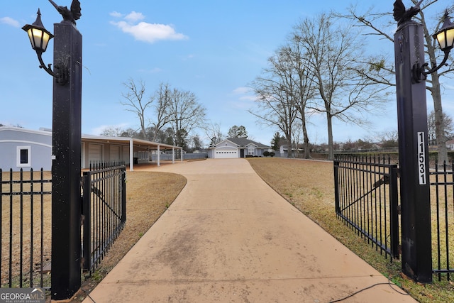 view of gate with a garage and a yard