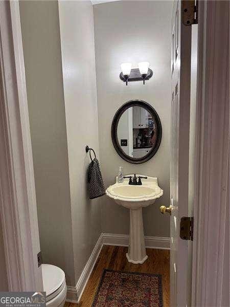 bathroom with sink, toilet, and hardwood / wood-style floors